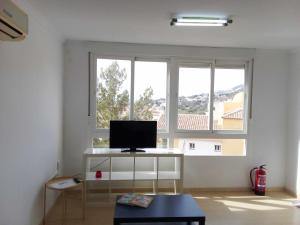 ベナルマデナにあるApartamento de 1 dormitorio en Calle Velaのリビングルーム(テレビ、大きな窓2つ付)
