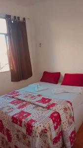 Pousada 146 في كامبوس دوس جويتاكازيس: غرفة نوم بسريرين وبطانيات حمراء وبيضاء