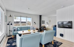 sala de estar con sofá azul, mesa y sillas en Lurifax en Hejls