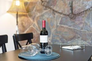 a bottle of wine and glasses on a table at La Casita de Vals in Valsequillo
