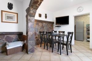a dining room with a table and chairs and a tv at La Casita de Vals in Valsequillo
