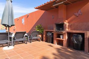 patio z krzesłami i parasolem w obiekcie La Casita de Vals w mieście Valsequillo