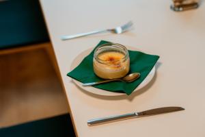 ein Glas Erdnussbutter auf einem Teller mit einem Löffel. in der Unterkunft Bergpension Laasen Perle Rathen in Kurort Rathen