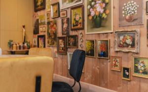 una habitación con pinturas en una pared y una silla en Time - Out Genoelselderen, en Riemst