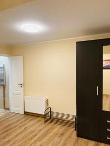 ein leeres Zimmer mit einer schwarzen Tür und Holzböden in der Unterkunft Nākotnes street apartaments in Liepāja