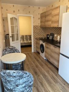 a kitchen with a table and chairs in a room at Nākotnes street apartaments in Liepāja +9 photos