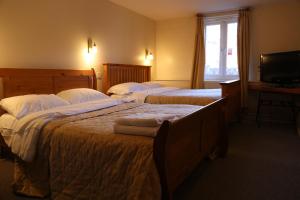 a hotel room with two beds and a television at Chequers Inn Hotel in Forest Row