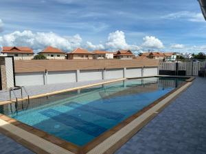 una piscina con acqua blu di fronte ad alcune case di Orient House a Pattaya Sud
