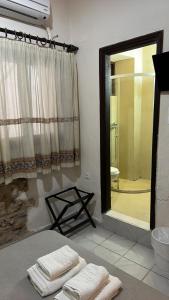 a bathroom with a shower and a bed with towels at Rethymno House in Rethymno Town