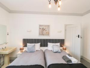two beds in a bedroom with a sink and a mirror at Crystal Cove in Bridlington