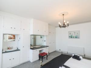 a kitchen with white cabinets and a sink and a mirror at Crystal Cove in Bridlington
