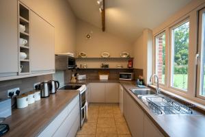 a kitchen with a sink and a counter top at Stackyard Lodge - enchanting 18th Century converted barn in the Waveney Valley in Aldeby