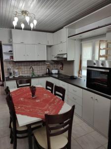 a kitchen with a table with a red table cloth on it at LHMNIA GH in Néa Koútali