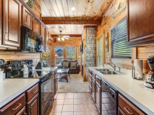a kitchen with wooden cabinets and a living room at Heaven's View, 2 Bedrooms, Sleeps 10, Hot Tub, Pool Table, Arcade, Jacuzzi in Gatlinburg