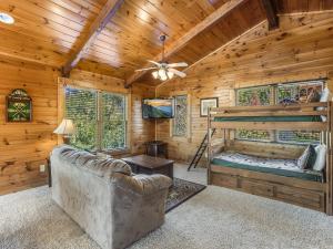 a living room with a couch and a bunk bed in a log cabin at Heaven's View, 2 Bedrooms, Sleeps 10, Hot Tub, Pool Table, Arcade, Jacuzzi in Gatlinburg