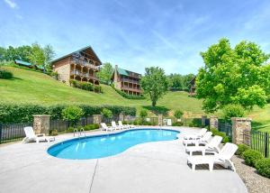 a swimming pool with white chairs and a house at A Mountain Paradise, 2 Bedrooms, Sleeps 6, Pool Access, Hot Tub, Pool Table in Pigeon Forge