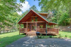 a log cabin in the woods with a porch at A Mountain Paradise, 2 Bedrooms, Sleeps 6, Pool Access, Hot Tub, Pool Table in Pigeon Forge