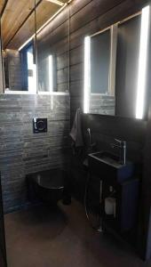 a bathroom with a black toilet and a sink at Luxury guesthouse, beachfront sauna in Jyväskylä