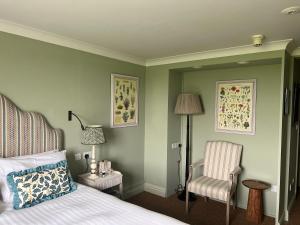 una camera con letto, sedia e lampada di The Barnsdale, Rutland a Oakham