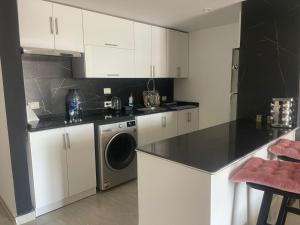 a kitchen with white cabinets and a washing machine at One bedroom marina city portghalib in Port Ghalib