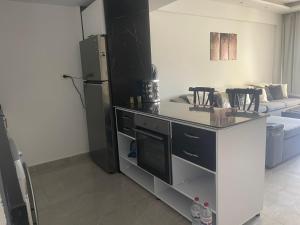 加利卜港的住宿－One bedroom marina city portghalib，厨房配有冰箱和带椅子的柜台