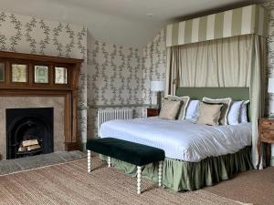 a bedroom with a large bed and a fireplace at The Barnsdale, Rutland in Oakham