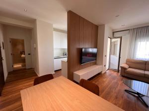 a living room with a table and a couch and a television at Skanderbeg Square Center Apartments in Tirana