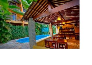 une terrasse avec un bain à remous, une table et des chaises dans l'établissement Apart Hotel Casa Grande, à Natal