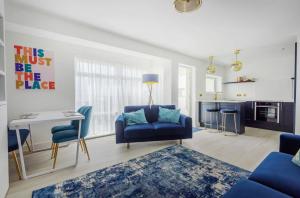 a living room with a blue couch and a table at Sunny View in East Wittering