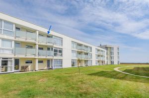a large white building with a grass field in front of it at Sunny View in East Wittering