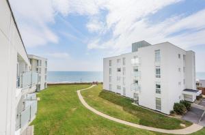 a view of two apartment buildings and the ocean at Sunny View in East Wittering