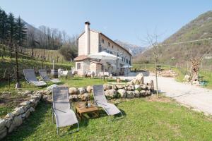 a group of chairs sitting in front of a building at Agriturismo Podere del Bosc in Valmareno