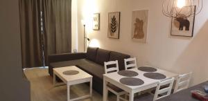 ein Wohnzimmer mit einem Sofa, einem Tisch und Stühlen in der Unterkunft Modern 1 Bed Seafront Apt Los Boliches in Fuengirola