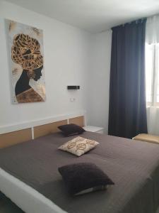 ein Schlafzimmer mit einem Bett mit einem Bild an der Wand in der Unterkunft Modern 1 Bed Seafront Apt Los Boliches in Fuengirola