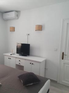 Schlafzimmer mit einem Bett und einem TV auf einem Schreibtisch in der Unterkunft Modern 1 Bed Seafront Apt Los Boliches in Fuengirola