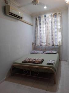 een klein bed in een kamer met een raam bij Welcome to Gemas Homestay ALI 