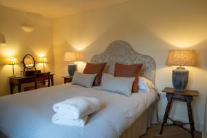 a bedroom with a large bed with two lamps at Stackyard Lodge - enchanting 18th Century converted barn in the Waveney Valley in Aldeby