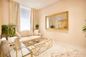 een woonkamer met een bank en een spiegel bij Beautifully decorated centrally located 2 bed flat in Brighton & Hove