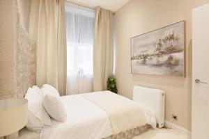 een witte slaapkamer met een bed en een raam bij Beautifully decorated centrally located 2 bed flat in Brighton & Hove