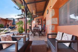 een patio met banken en een tafel en stoelen bij Villa La Quinta de Vals in Valsequillo