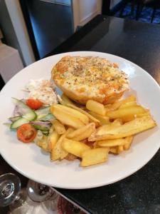 a plate of food with a chicken and french fries at Y Castell in Caernarfon