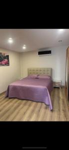 een slaapkamer met een bed met een paarse deken bij Elit semtte muhteşem konumda daire in Antalya