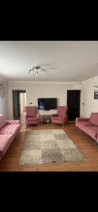 a living room with pink furniture and a flat screen tv at Elit semtte muhteşem konumda daire in Antalya