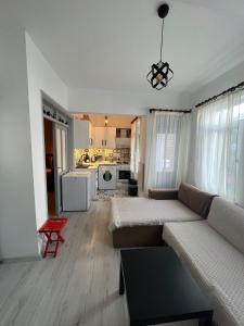 a living room with a couch and a kitchen at Centeral Apartment in Kaş