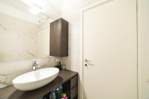 a bathroom with a white sink and a mirror at Milan Design Suite - Palestra e Parcheggio Privato in Milan