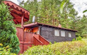 a wooden house with a red fence and trees at Gorgeous Home In Biskupiec With Kitchen in Wilimy