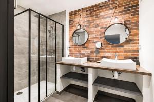 a bathroom with two sinks and a brick wall at Le Grand Fauriel 100m 6 places in Saint-Étienne