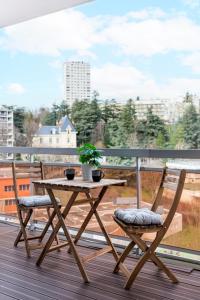 a wooden table and two chairs on a balcony at Le Grand Fauriel 100m 6 places in Saint-Étienne