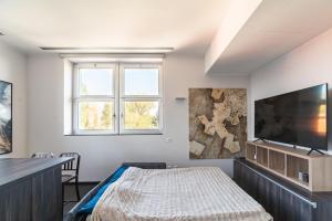 a bedroom with a bed and a flat screen tv at Milan Design Suite - Palestra e Parcheggio Privato in Milan