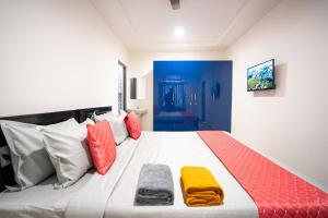 a bedroom with a large bed with colorful pillows at Yellow Bells Signature HITEC City in Hyderabad